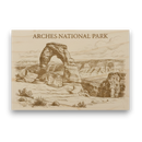 Wooden sign with engraved image of Arches National Park and text.