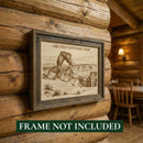 Framed artwork of Arches National Park on a wooden wall with 'Frame Not Included' text.