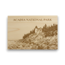 Wooden plaque with engraved illustration of a lighthouse and 'Acadia National Park' text on a white background