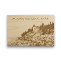 Wooden plaque with engraved illustration of a lighthouse and 'Acadia National Park' text on a white background