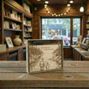Engraved wooden plaque with a father and son fishing illustration on a wooden table.