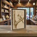 Decorative box with a cardinal illustration and text on a wooden surface.