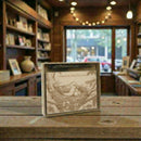 Wooden box with bird design on a wooden table in a cozy bookstore setting