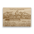 Wooden plaque with engraved illustration of a barn and mountains labeled 'Grand Teton National Park'.