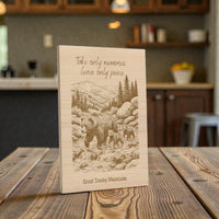 Wooden plaque with bear illustration and text on a wooden table in a kitchen setting