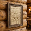 Wooden framed artwork with nature-themed design on a log cabin wall.
